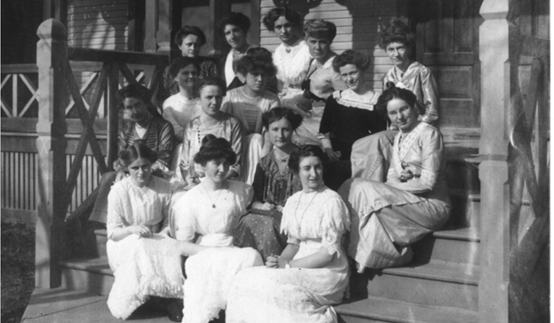 Theta Phi Alpha Founders sitting on wooden steps